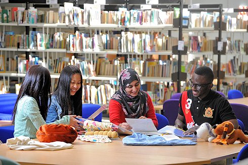 Four students work in the library